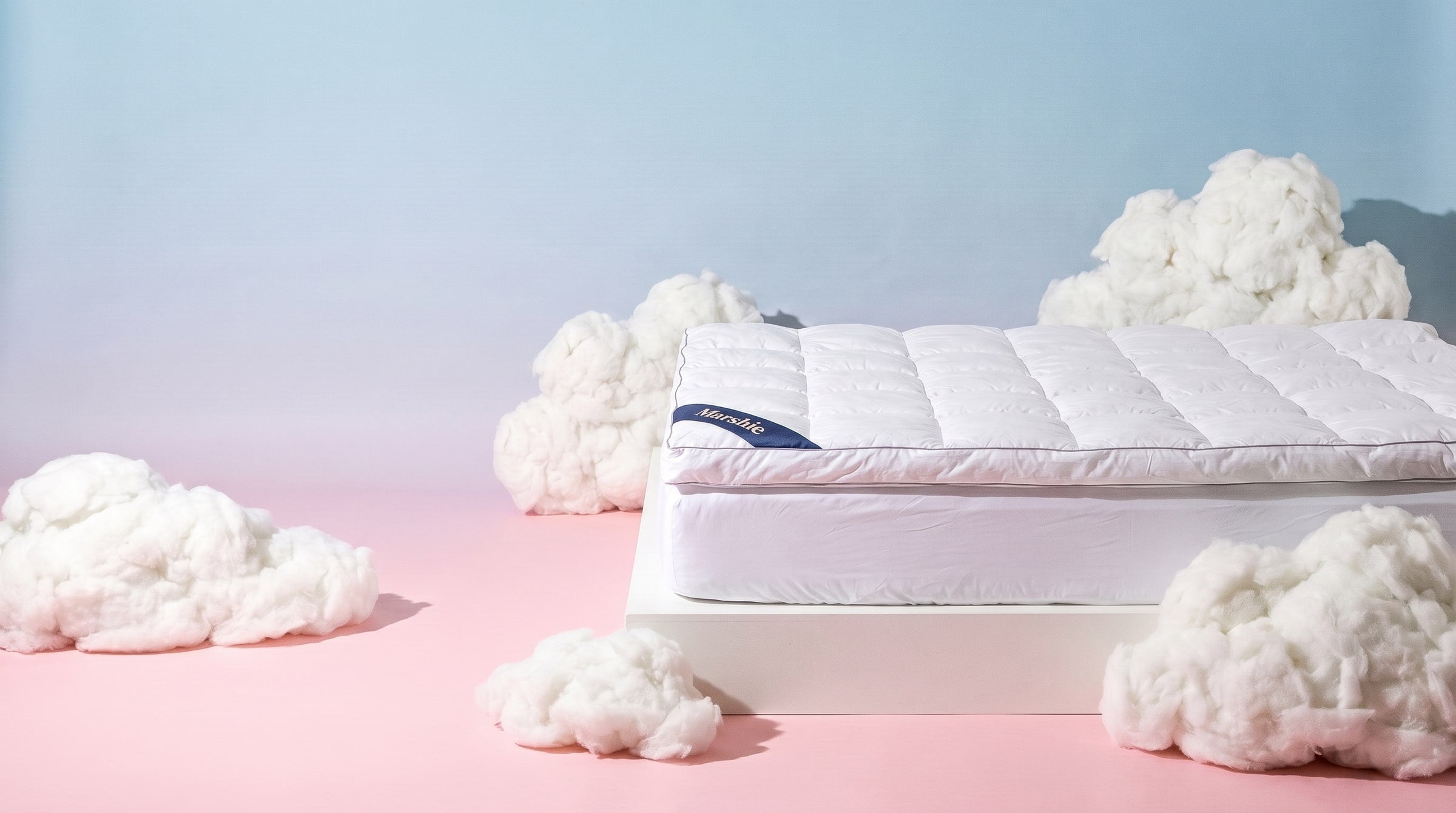 The Marshie Topper on a white bed base between soft white clouds