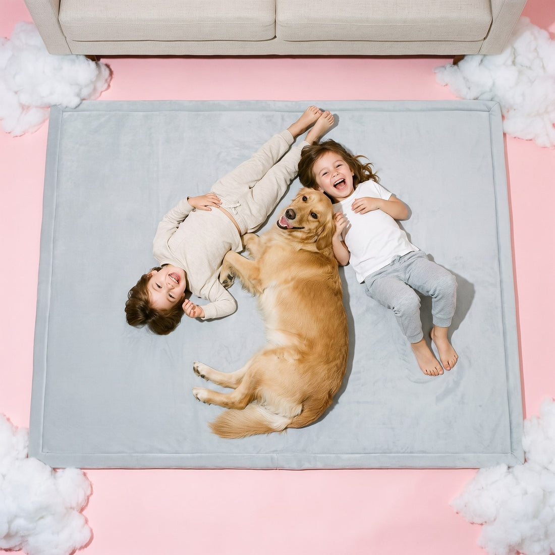 Two kids and a golden retriever lying on a Stone Grey Marshie Mat seen from above